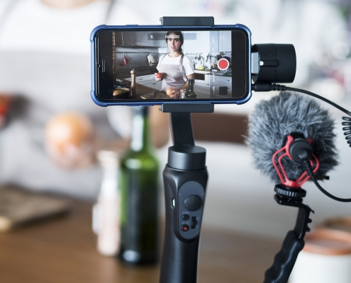 a phone a microphone set up to record a video in a kitchen