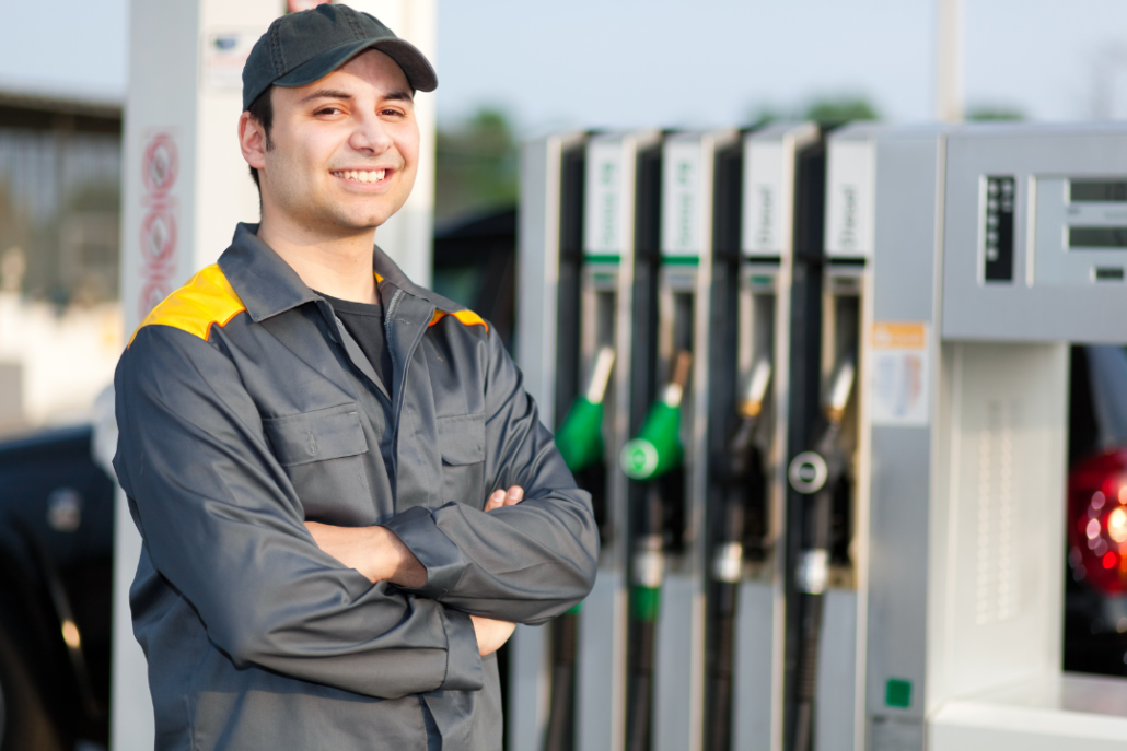 stock image of fuel service technician in front of fuel pumps